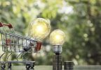 Energy saving light bulb with stacks of coins and shopping cart for saving, financial and shopping concept  and copy space for insert text.